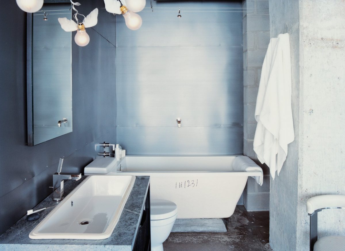 winged light bulbs part of an ingo maurer fixture bring levity to hills bathroom the space features a zinc wall by houston metalworker george sacaris who also did the bathroom and kitchen cabinets