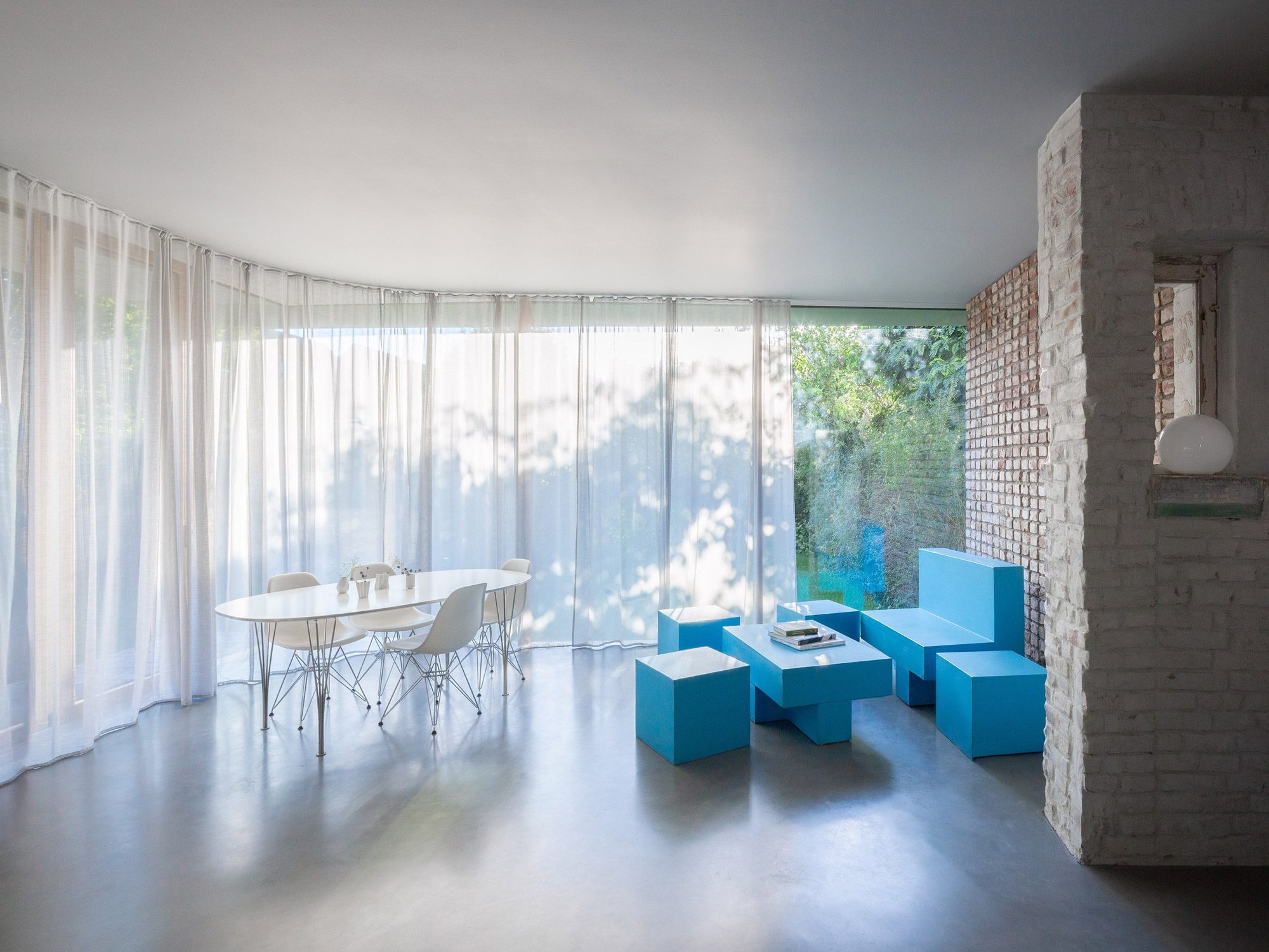 Brick to Light 곡선 벽 거실, 파란 가구와 노출 벽돌 기둥