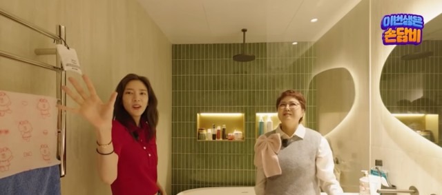 손담비가 올리브 그린 타일 욕실에서 인테리어를 소개하는 모습