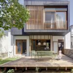 정원 덱과 그을린 목재 상부 증축이 보이는 Waverley House 외관