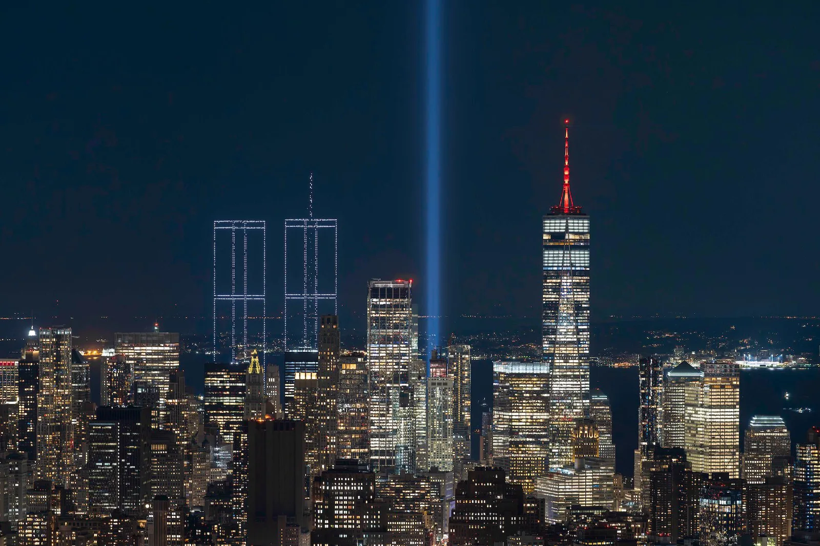 뉴욕 항구 위에 드론으로 재현된 9&middot;11 Twin Towers 야경, 옆으로 One World Trade Center가 보인다