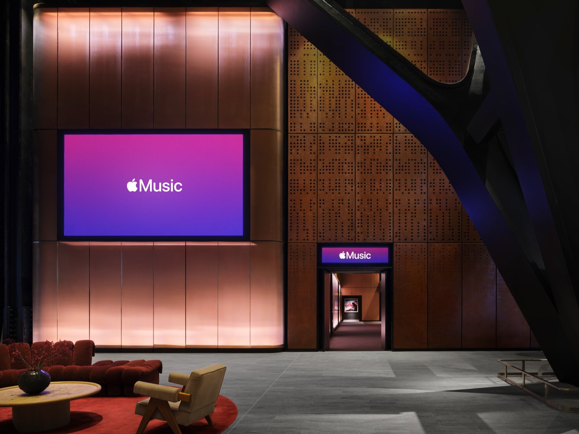 타공 브론즈 벽과 리브 패널이 마주 선 Apple Music Hall 로비