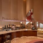 harudot 로고가 붙은 곡면 벽 아래 커피 바와 체크 패턴 바닥