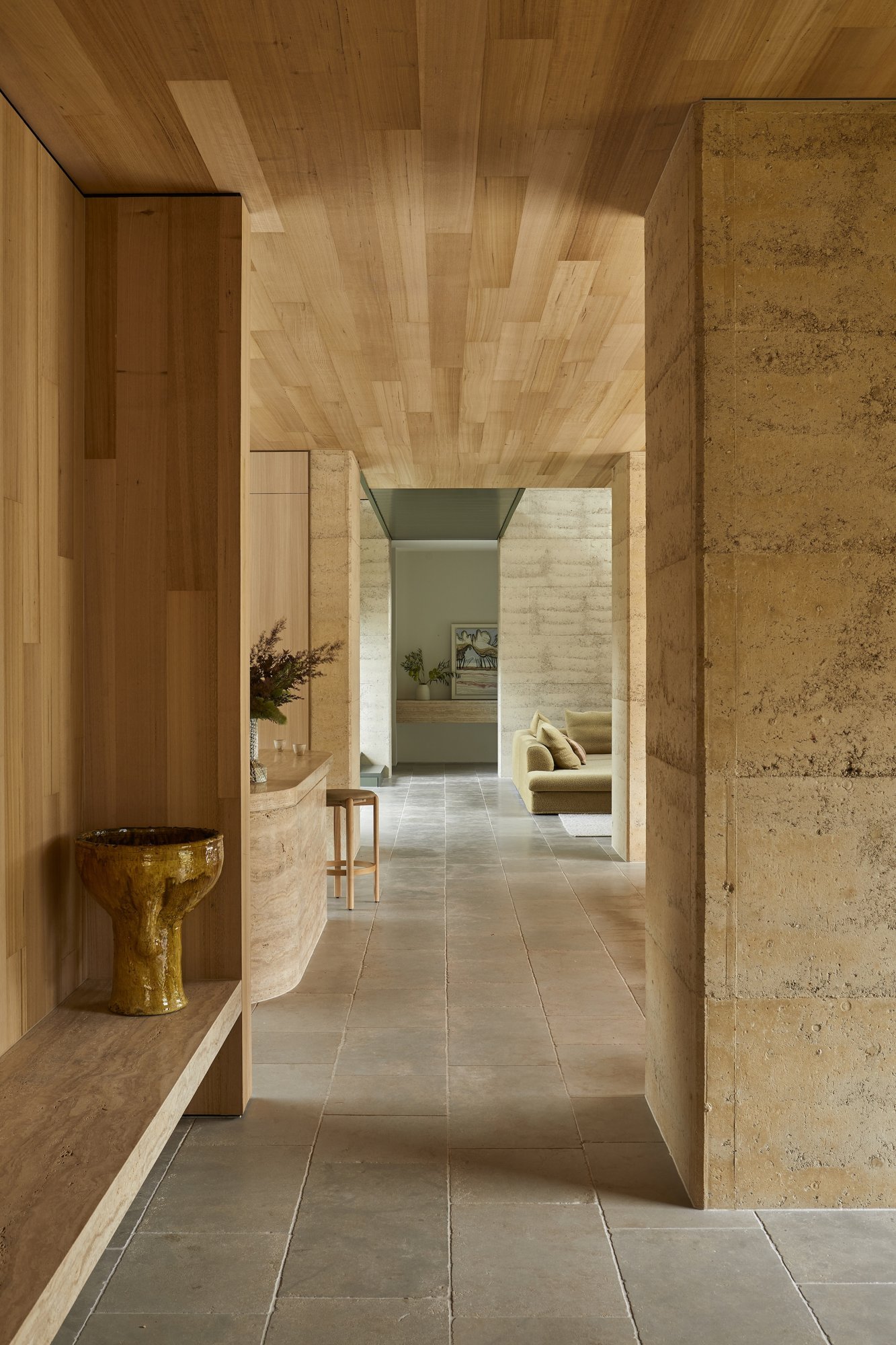 흙다짐 벽과 하드우드 천장 사이로 이어지는 Barwon Dunes House 현관 복도