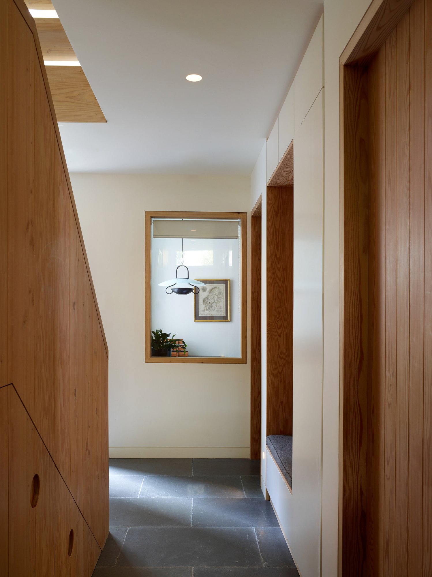슬레이트 바닥과 더글러스퍼 벽장이 이어지는 Danish Mews House 1층 복도