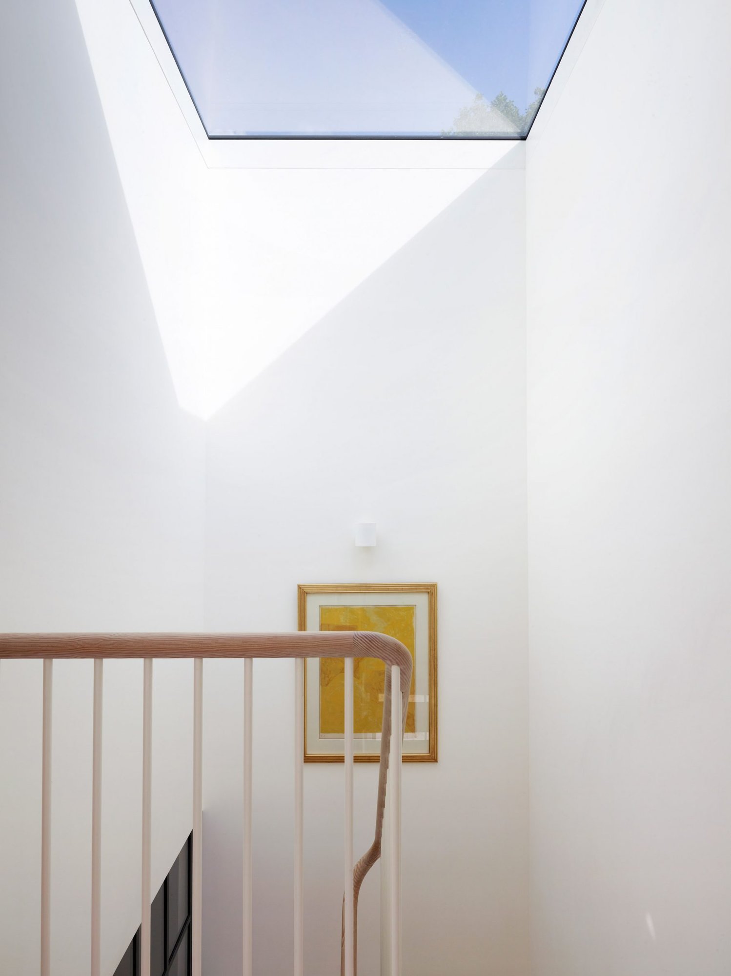 계단실 꼭대기 천창에서 빛이 쏟아지는 Danish Mews House