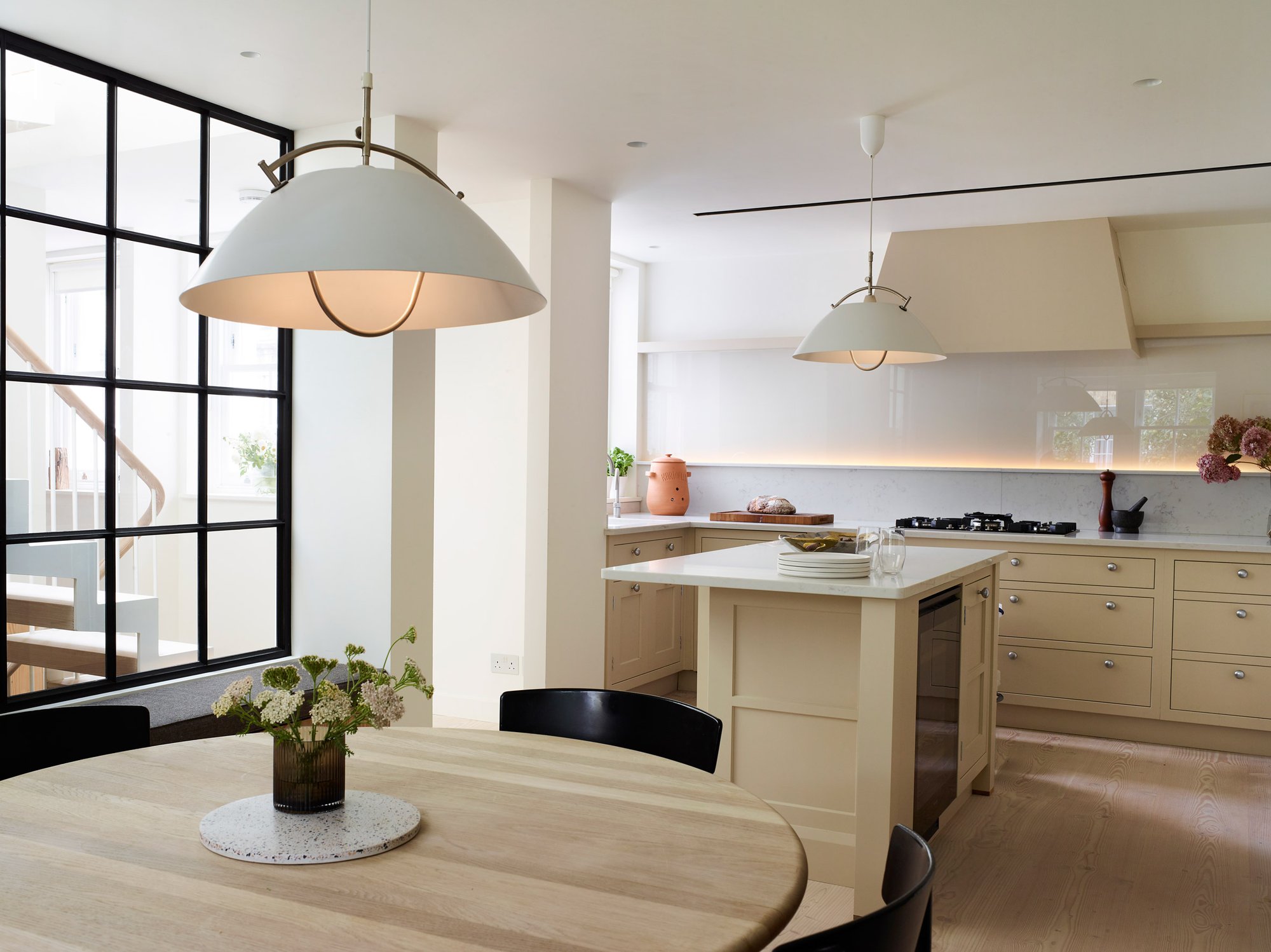 오트밀 컬러 주방과 화이트 펜던트 조명이 있는 Danish Mews House 다이닝