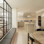 격자 유리벽 옆 벤치와 주방이 이어지는 Danish Mews House