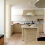 아일랜드와 오트밀 컬러 수납장을 둔 Danish Mews House 주방