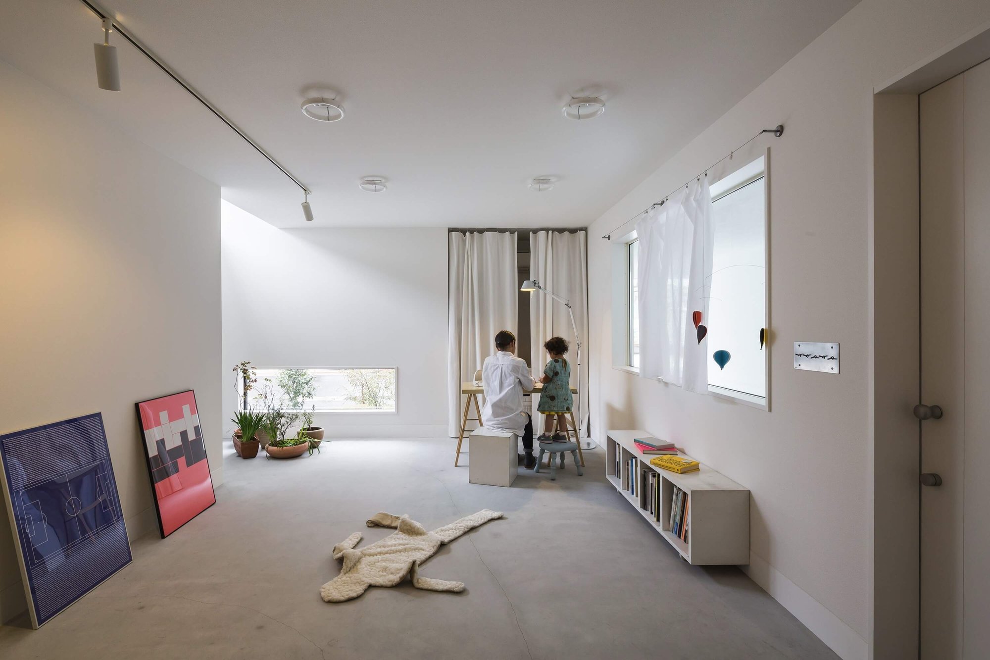 모르타르 바닥과 화이트 미장 벽으로 마감한 Framing House 1층 갤러리