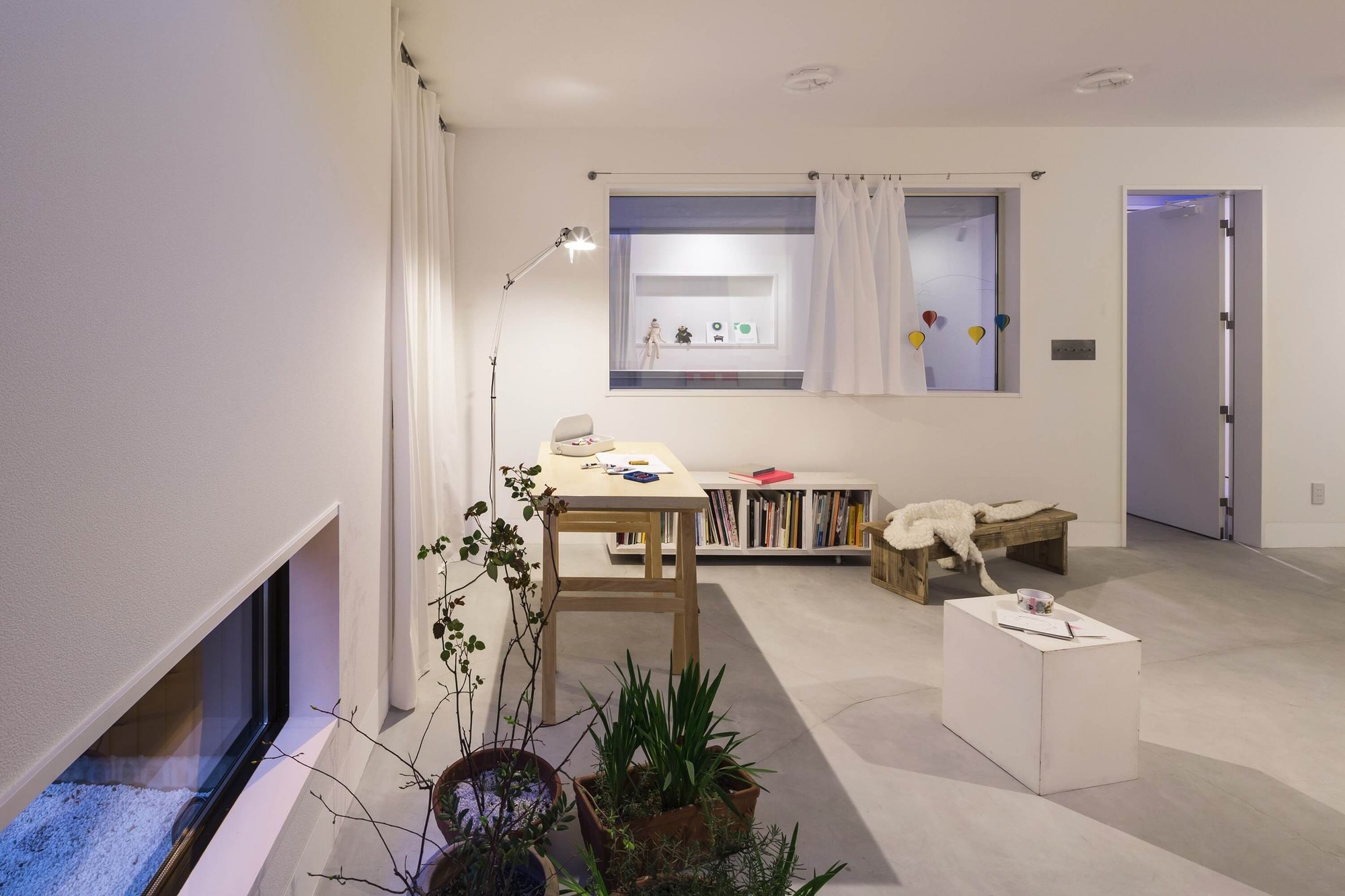 거리 쪽 낮은 띠창과 작업 테이블이 놓인 Framing House 갤러리