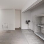 천창과 모르타르 책장이 있는 Framing House 2층 거실 전경