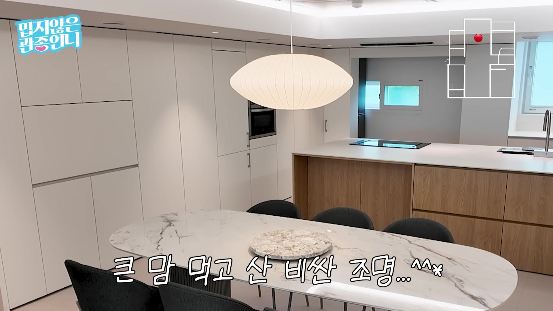 버블 펜던트 조명이 걸린 다이닝 테이블과 대면형 아일랜드 주방