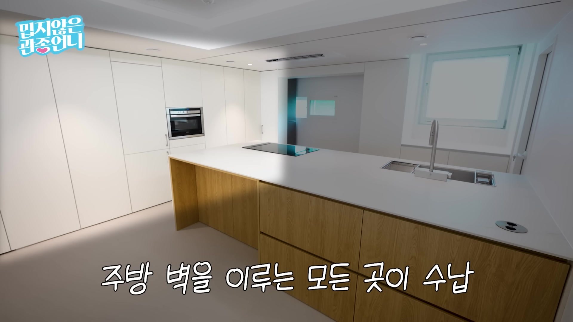 벽 전체를 손잡이 없는 수납장으로 채운 화이트 주방