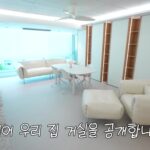 창가 쪽 테이블과 화이트 소파가 놓인 거실 전경