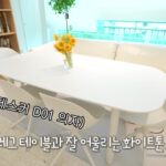 높이 조절 테이블과 화이트 의자 세트를 둔 거실 창가