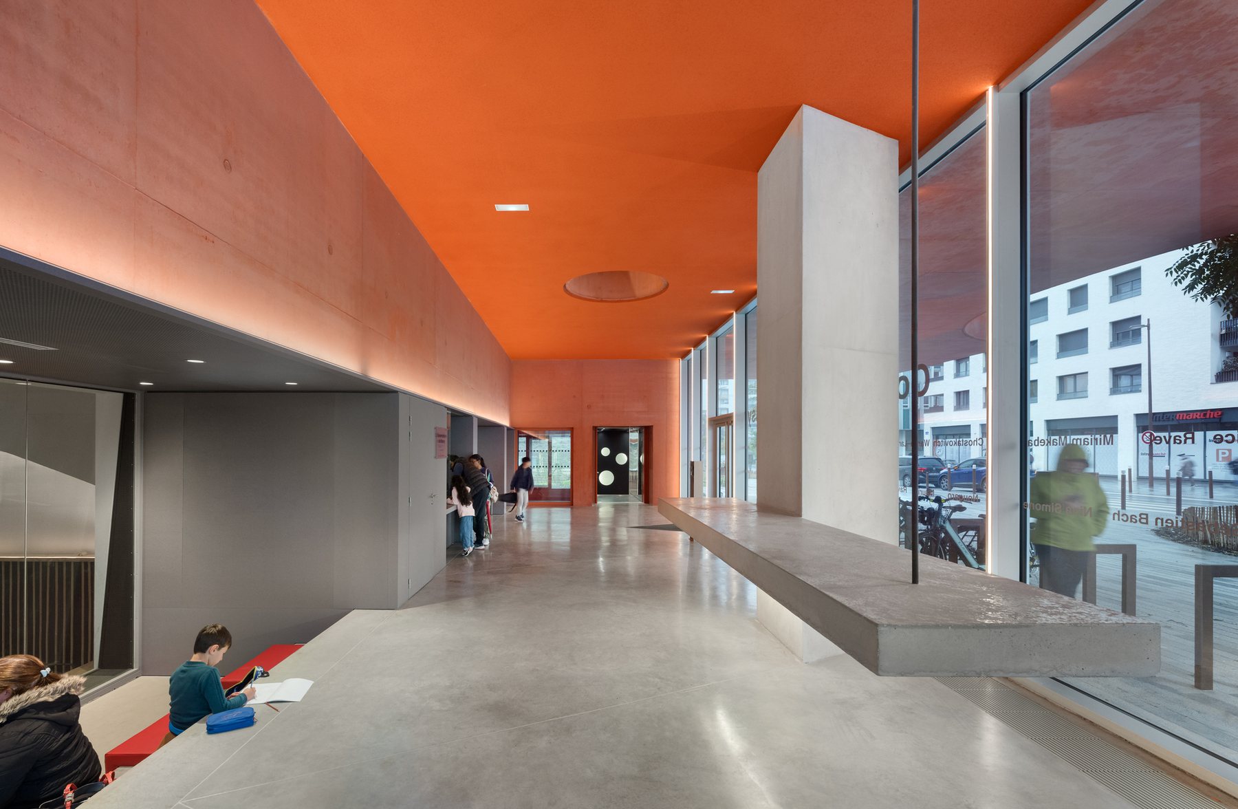 오렌지 천장과 통유리로 둘러싼 Massy Conservatoire 1층 리셉션 홀
