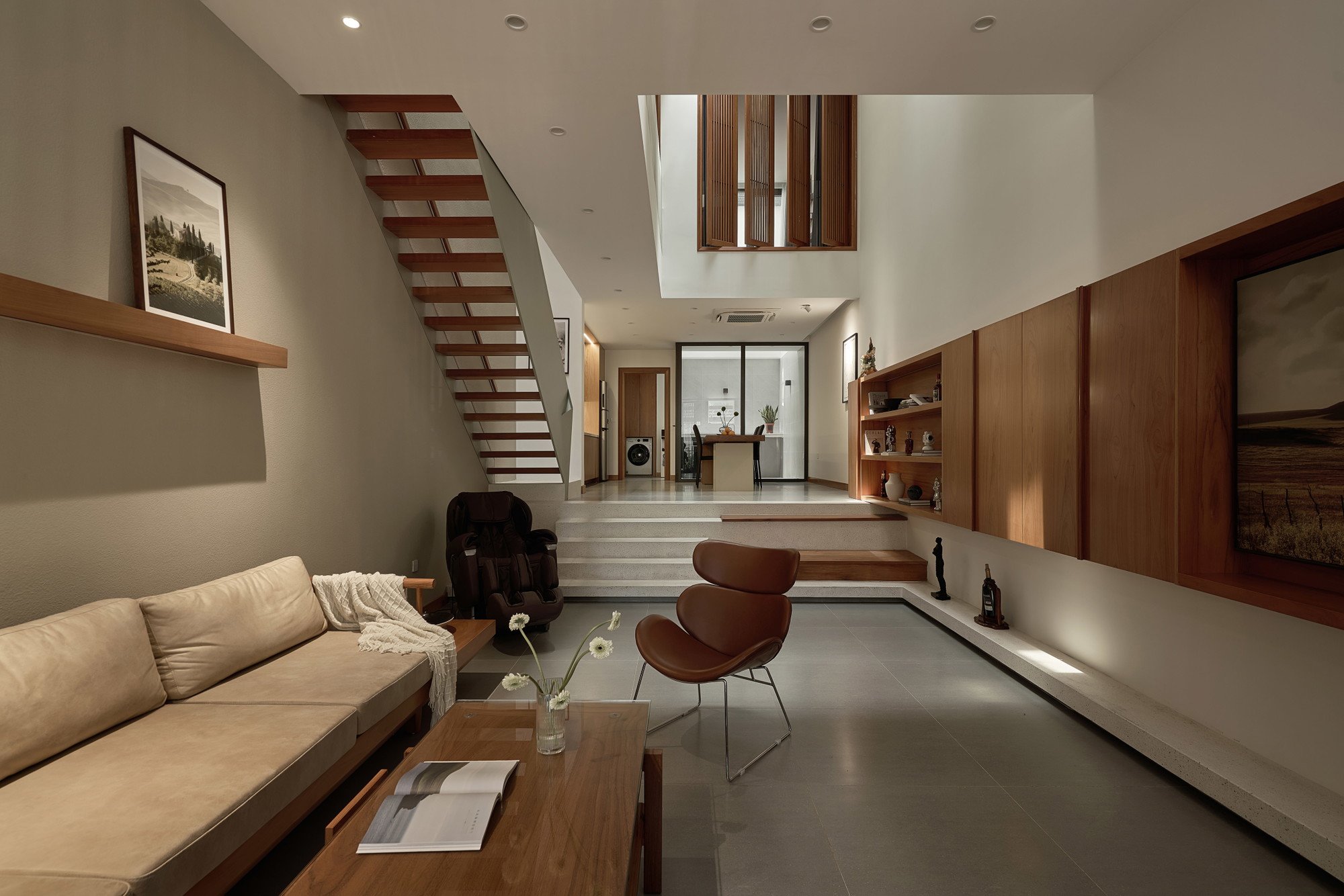 중앙 스카이라이트 보이드 아래로 이어지는 PAMA House 거실과 주방