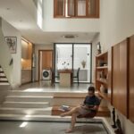 단차 계단에 앉아 책을 읽는 PAMA House 거실 풍경