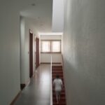 좁은 복도 끝 계단실이 보이는 PAMA House 내부