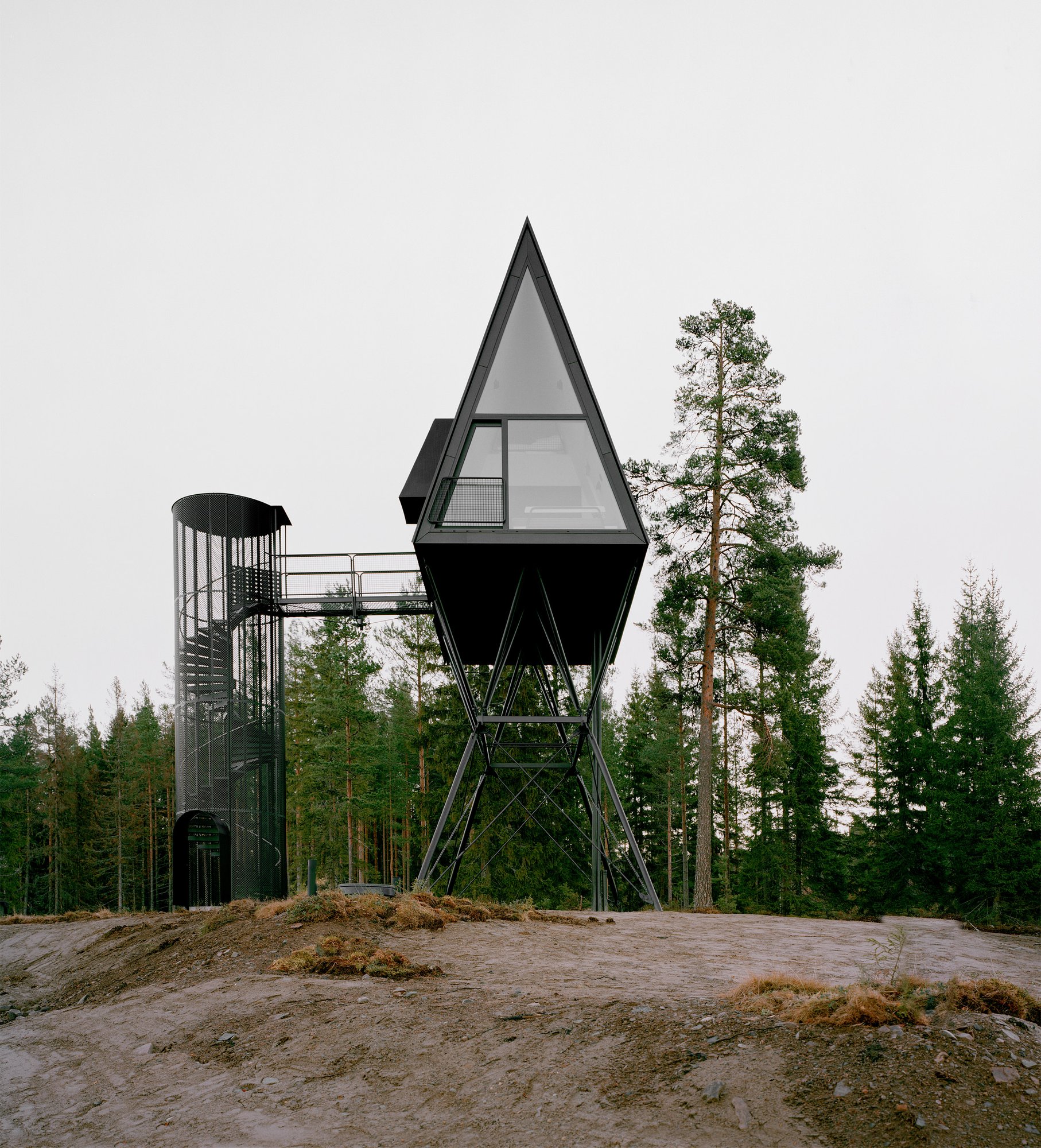 바위 언덕 위에서 본 PAN Treetop Cabins의 뾰족한 A프레임 박공 정면
