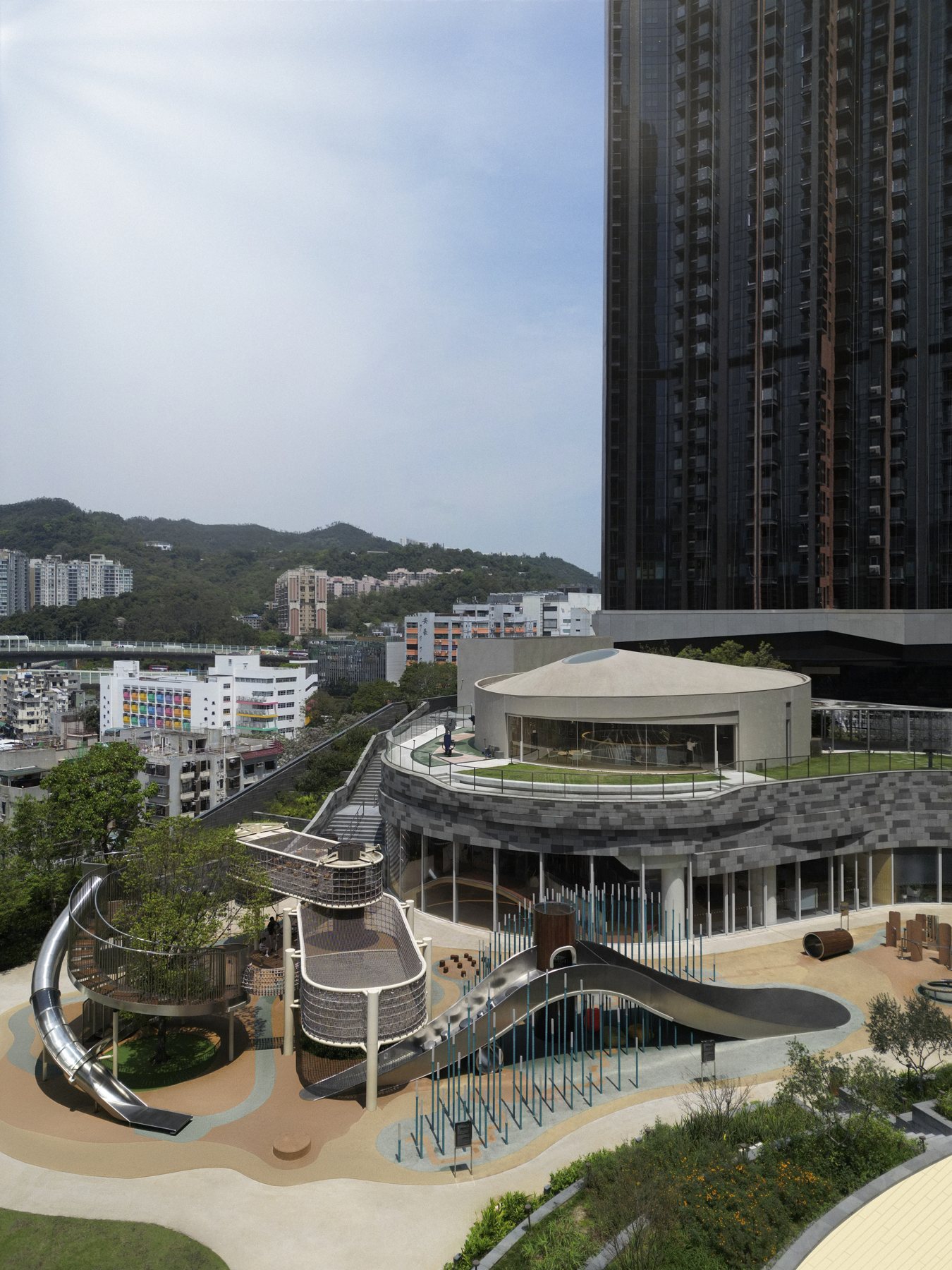 아파트 타워 옆 옥상에 놓인 원형 Sky House와 미끄럼틀 놀이터 항공 전경