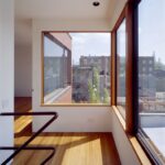 코너 창 아래 햇빛이 떨어지는 Pfanner House 오크 바닥