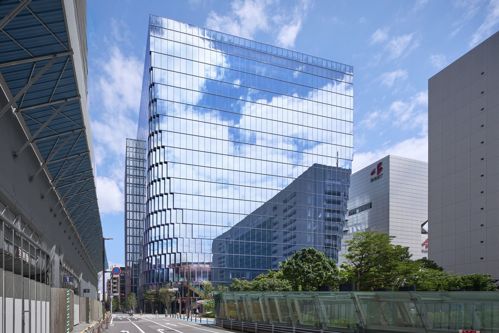 푸른 하늘을 비추는 유리 커튼월의 Tenjin Business Center II 외관 전경