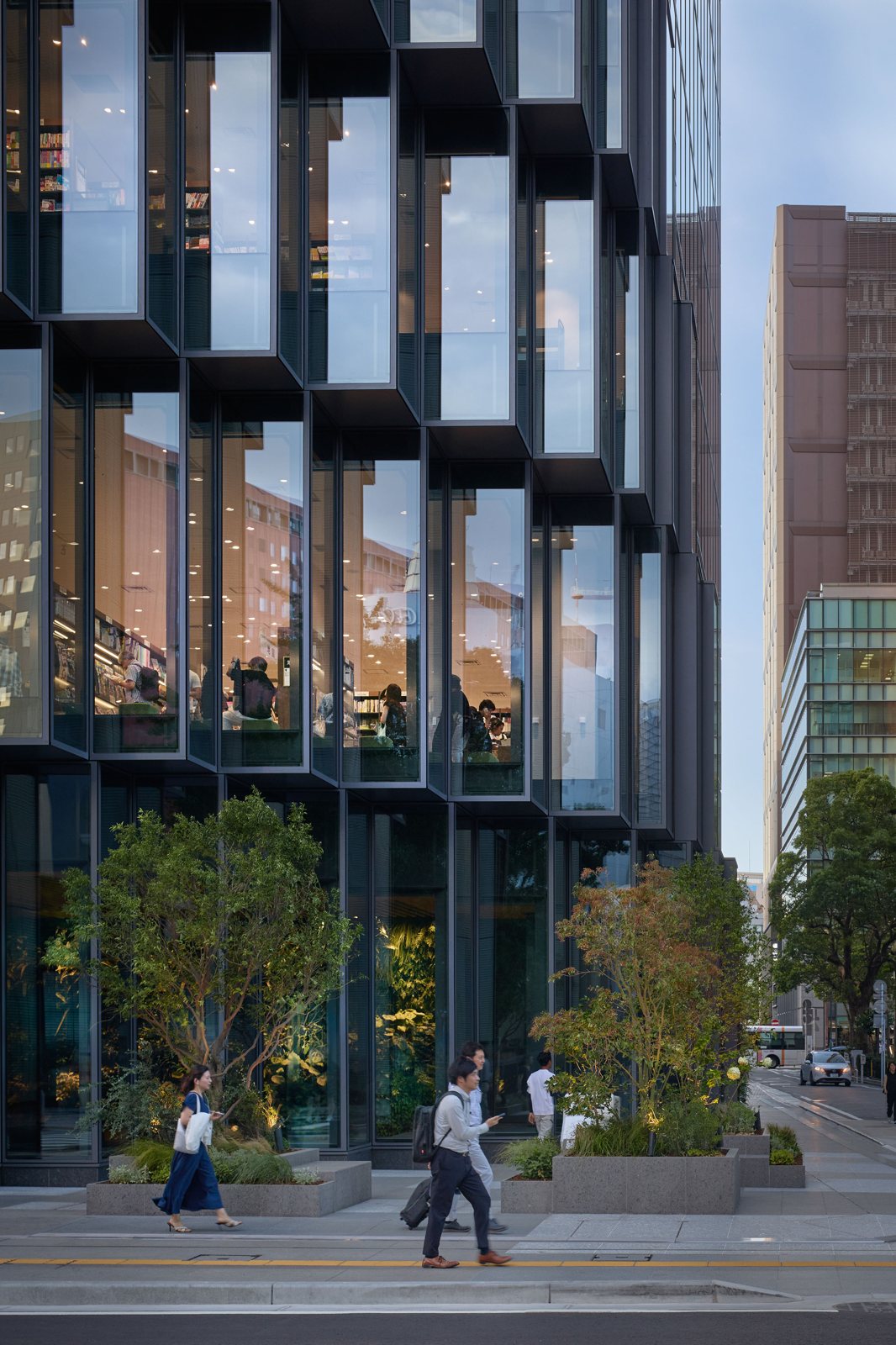 가로수와 보행자가 지나는 Tenjin Business Center II 저층부 파사드