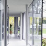 전면 유리 사이로 길게 이어지는 Ring House 복도 세로 컷