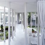 커튼과 가는 기둥 사이로 중정이 보이는 Ring House 파빌리온 내부