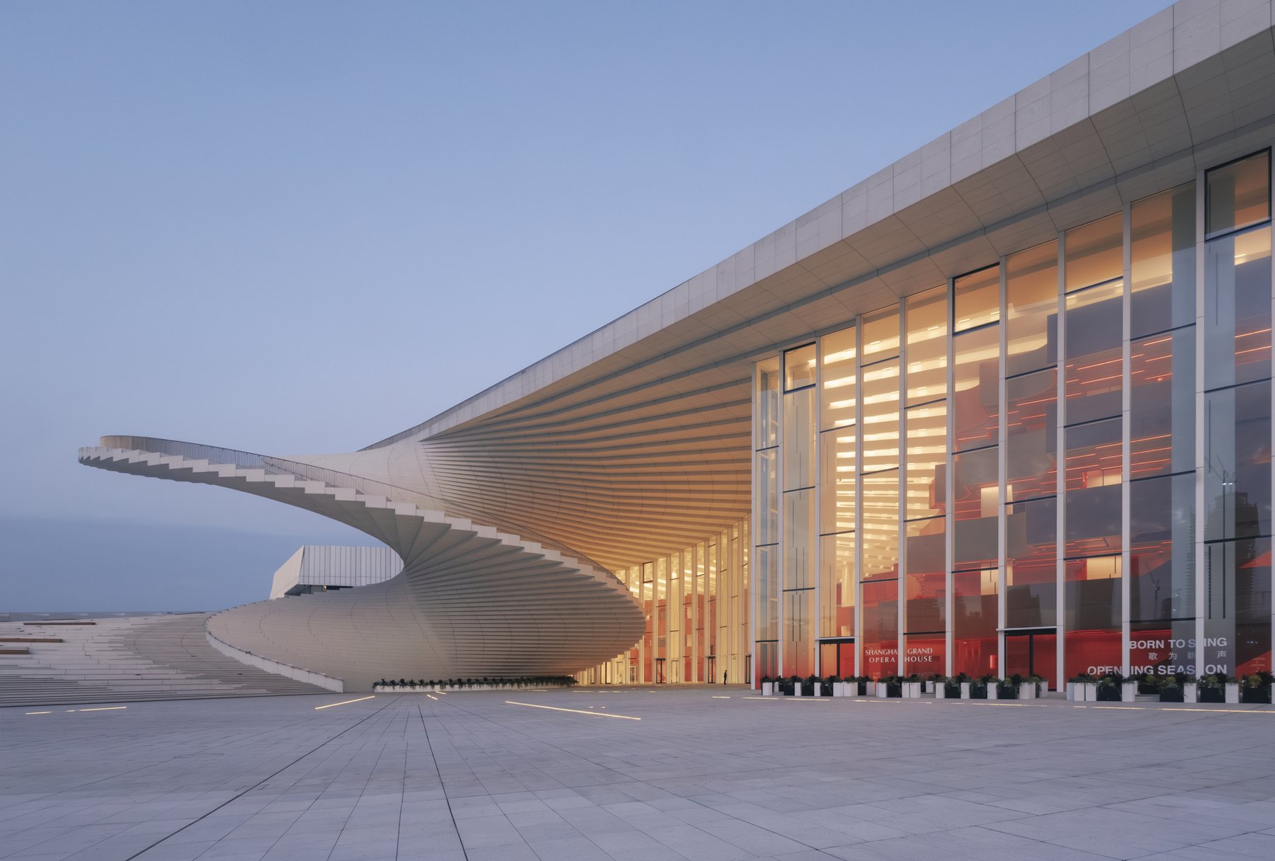 해 질 녘 조명이 켜진 Shanghai Grand Opera House의 나선 계단과 외관