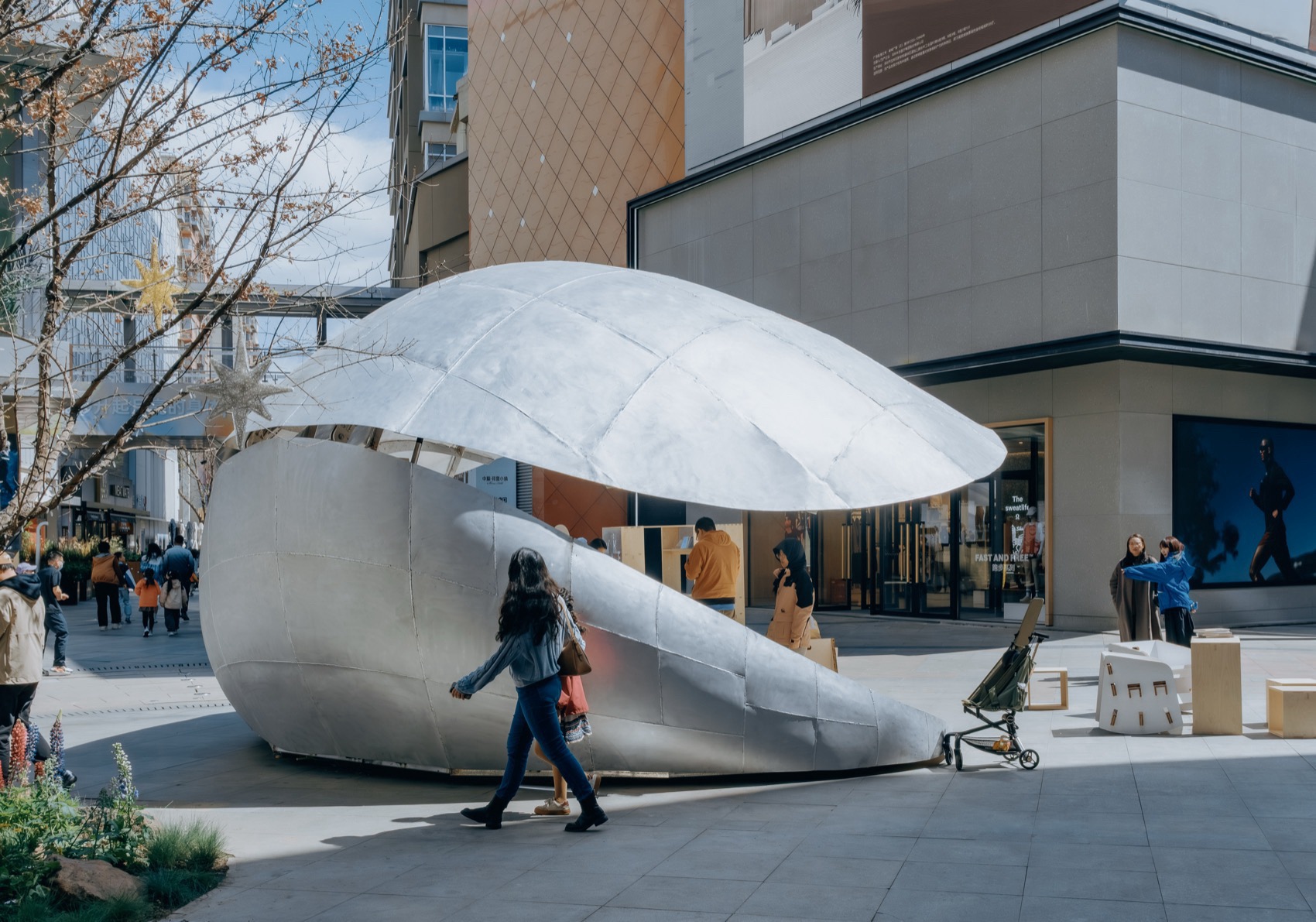 반쯤 열린 Shell Book Pavilion 옆을 지나가는 보행자
