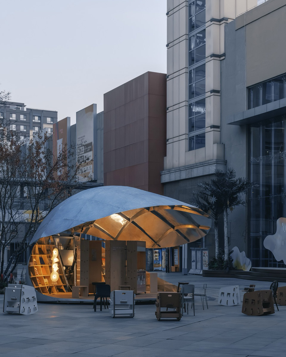 밤에 랜턴처럼 빛나는 Shell Book Pavilion 내부 조명