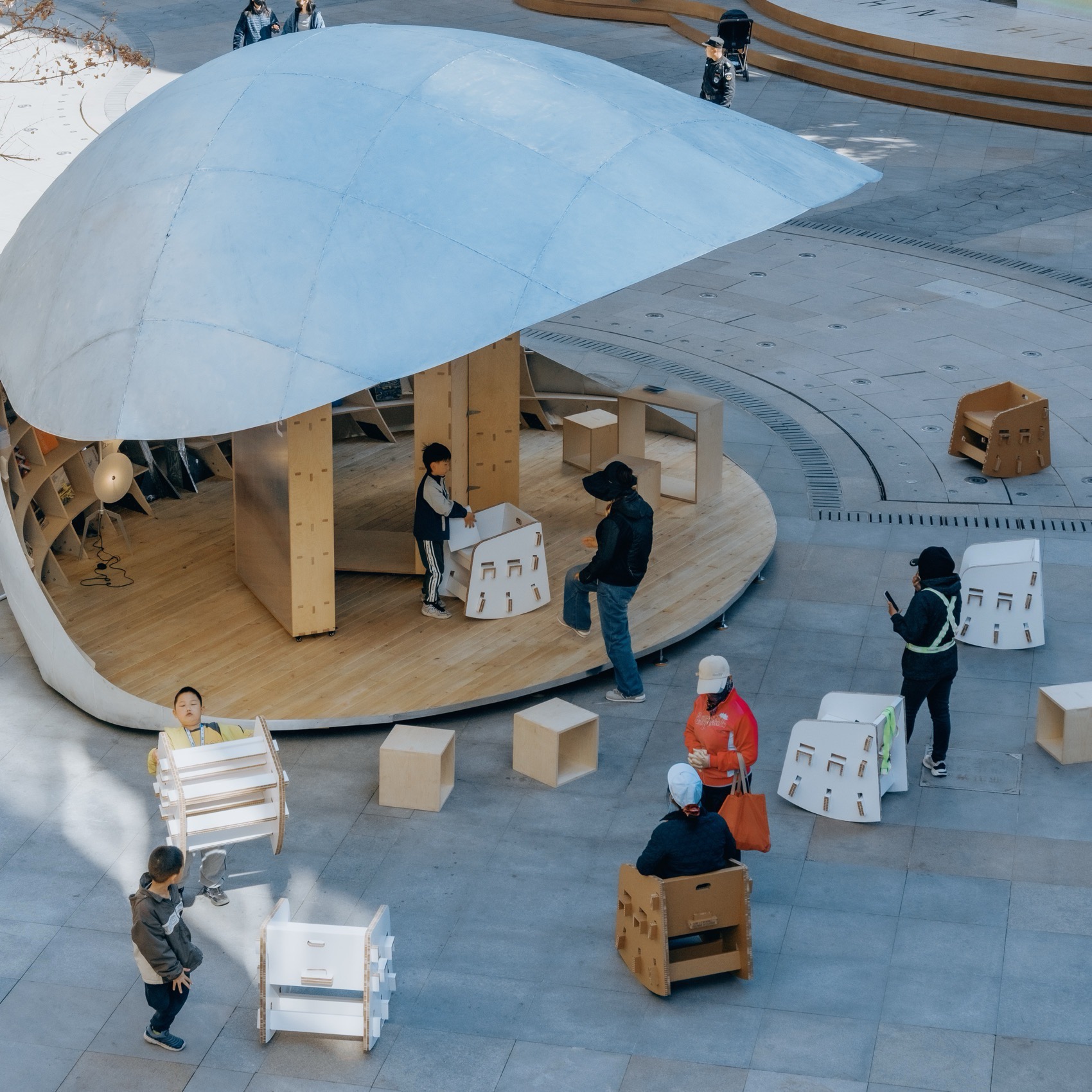 위에서 내려다본 Shell Book Pavilion 원형 목재 데크와 광장의 의자들
