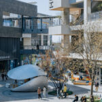 나무 사이로 보이는 반쯤 닫힌 Shell Book Pavilion