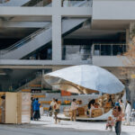 상업단지 건물과 에스컬레이터를 배경으로 한 Shell Book Pavilion