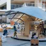 열린 Shell Book Pavilion 아래 데크와 가벼운 의자들