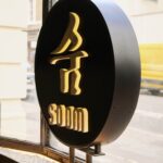 창가 자갈 위에 세운 Soom 원형 로고 사인