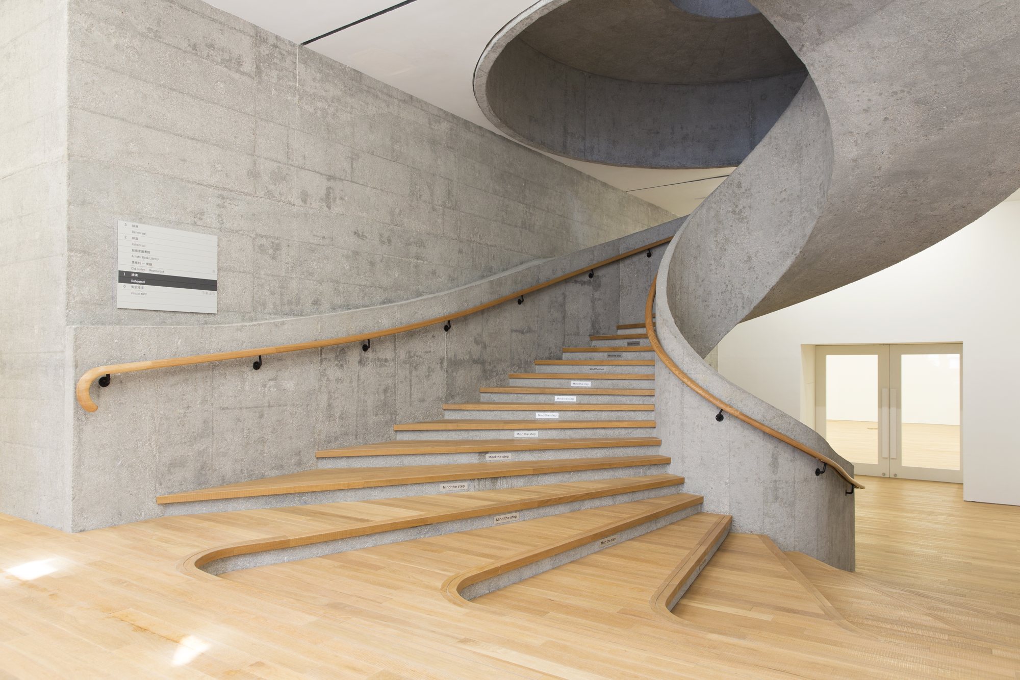 JC Contemporary 내부의 노출 콘크리트 나선계단과 오크 마루