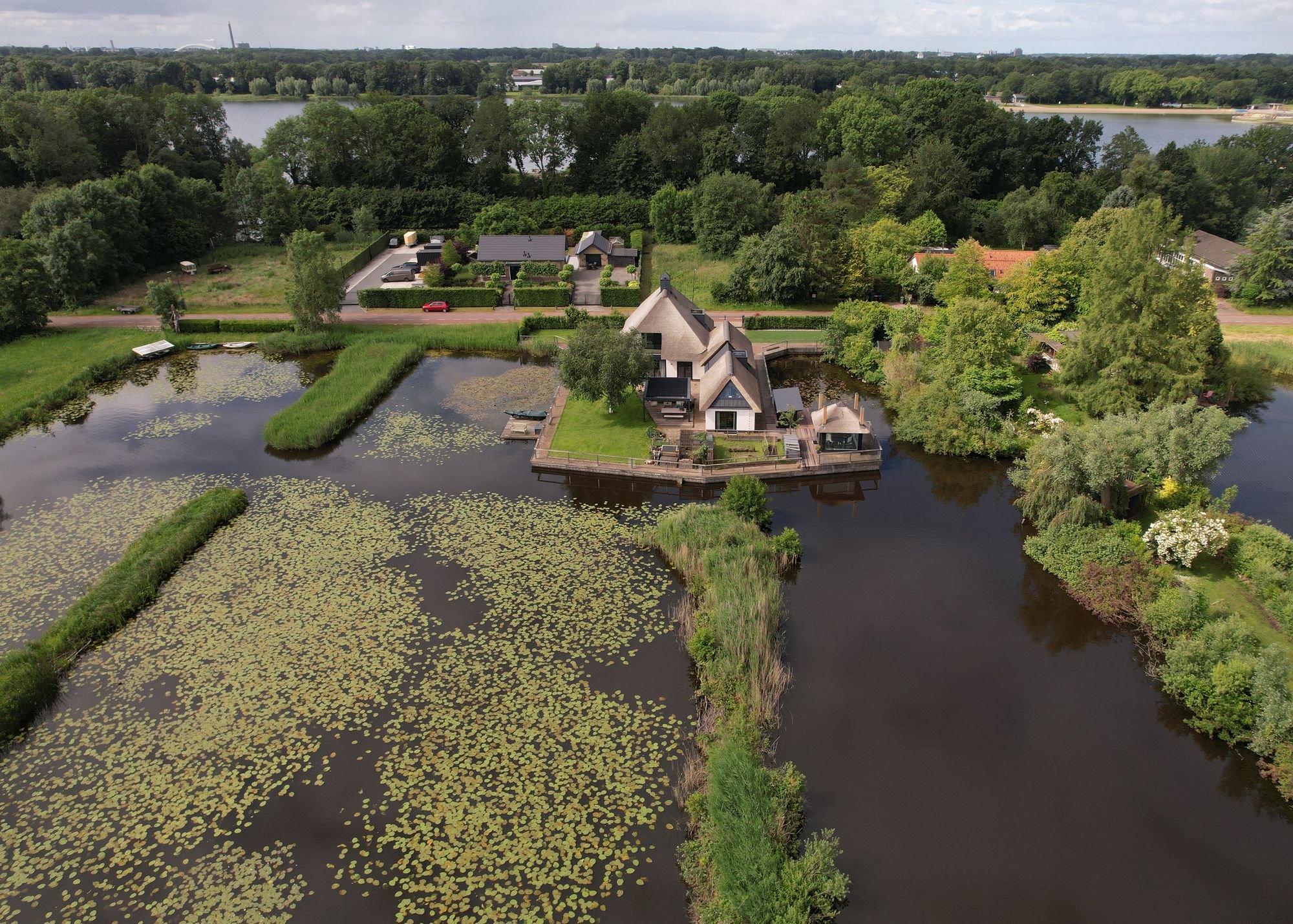 삼면이 물로 둘러싸인 정원 위 Tienhoven Country Villa 본채와 보트하우스 항공 사진