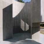 곡면 벽 사이로 하늘이 열린 Trefoil House 파티오