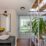 계단 옆 세면대가 놓인 White Modular House 하층 복도